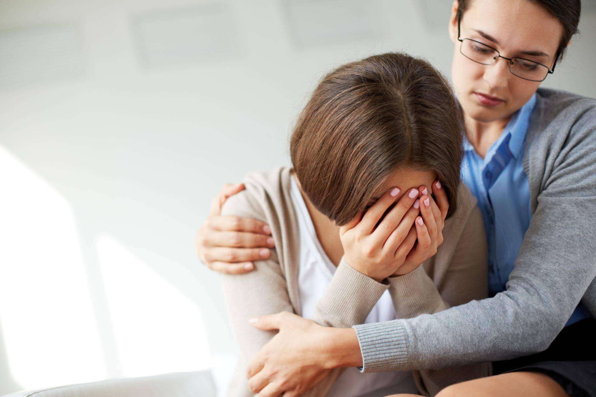 Woman comforting another upset crying woman